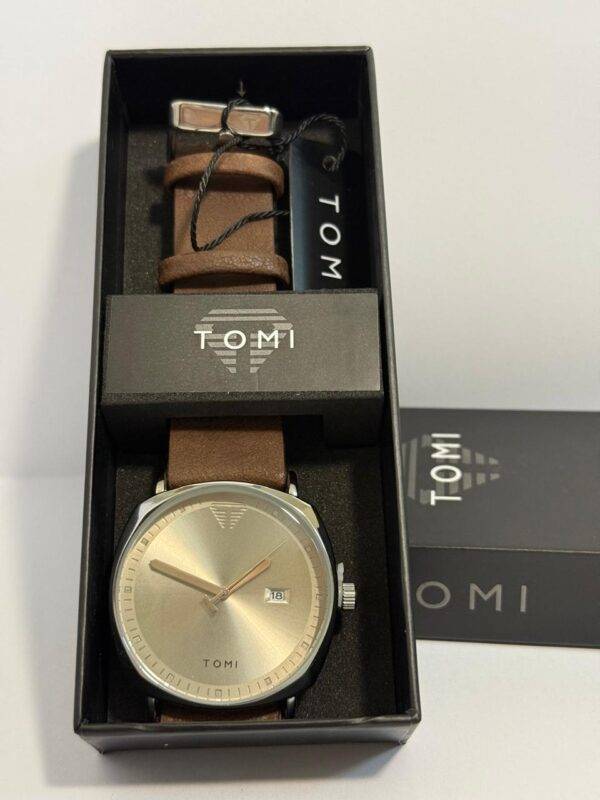 TOMI watch with black dial and blue second hand, brown leather strap, in black branded box.