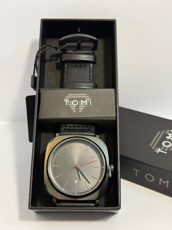 Close-up of TOMI Watch featuring gray dial and black leather strap.