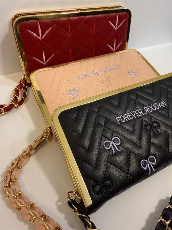 Rear view of red quilted wallet with detachable gold strap.